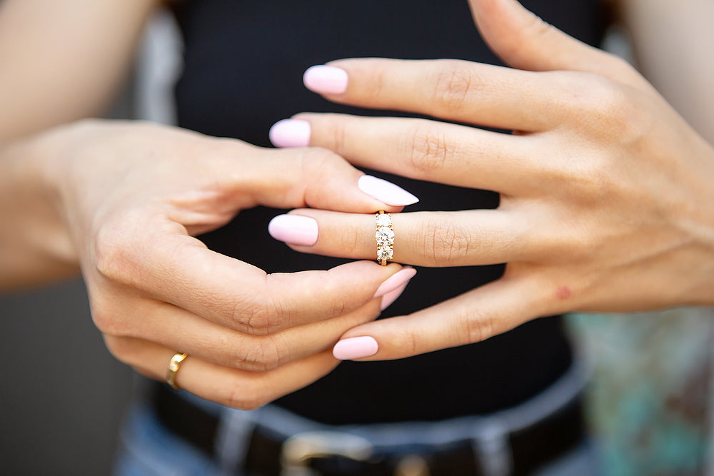 moissanite trilogy engagement ring shown on a finger - Victoria's Jewellery