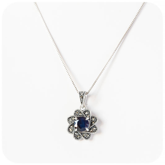 round cut blue sapphire pendant in a vintage inspired flower setting