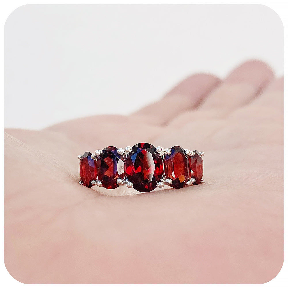 oval cut red garnet half eternity anniversary or birthstone ring