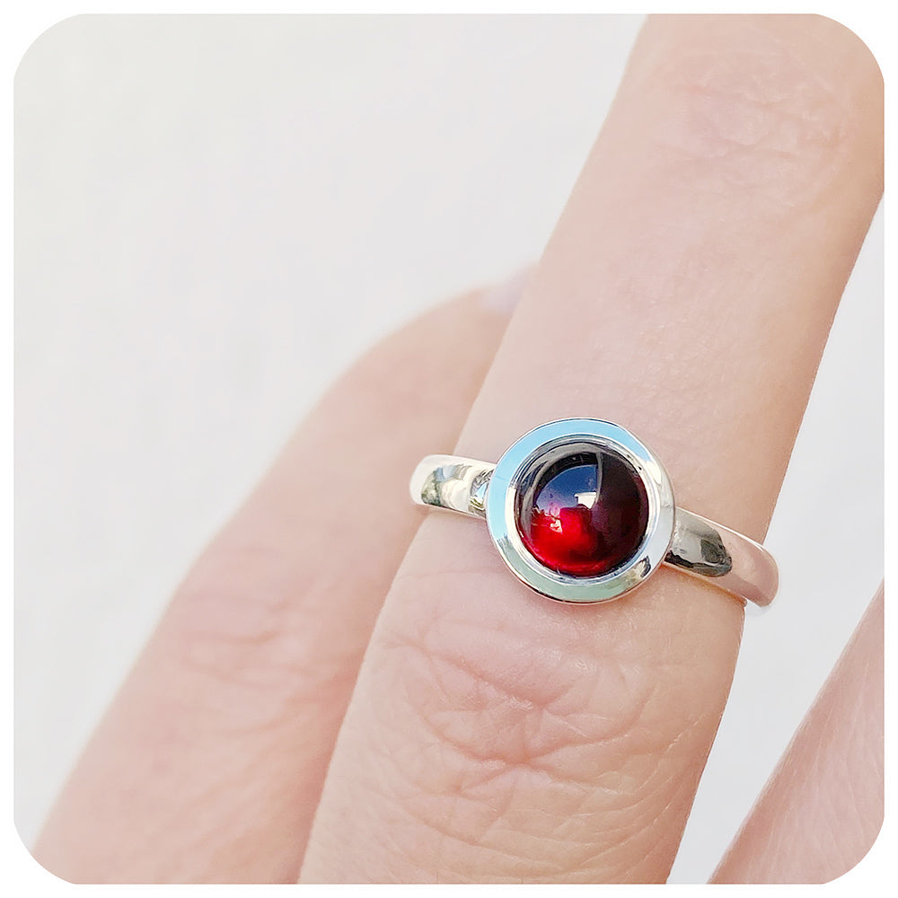 round cabochon rhodolite solitaire ring in a bezel setting