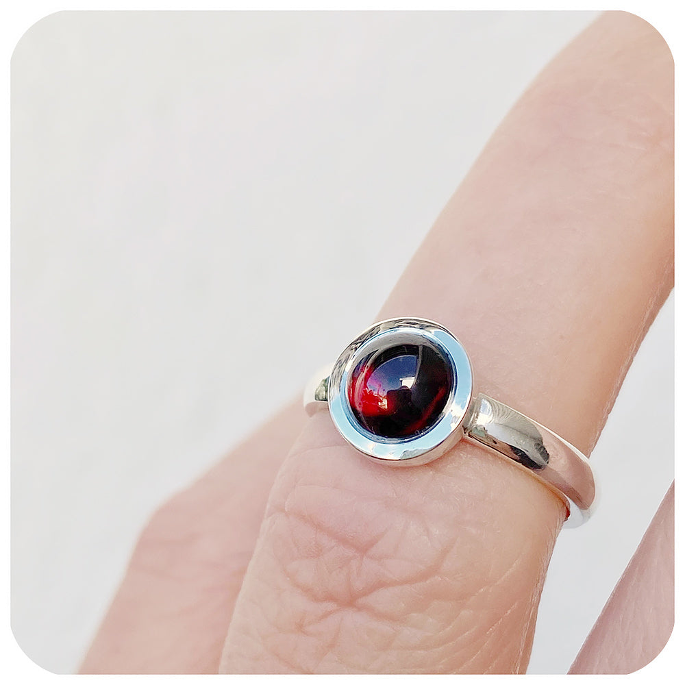 round cabochon rhodolite solitaire ring in a bezel setting