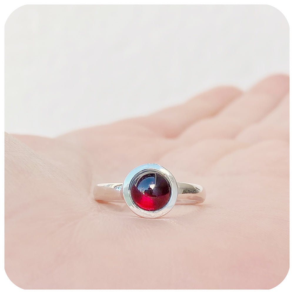 round cabochon rhodolite solitaire ring in a bezel setting