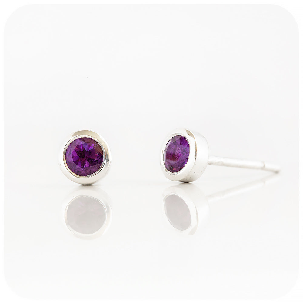 round cut purple amethyst stud earrings in a sterling silver bezel tube setting