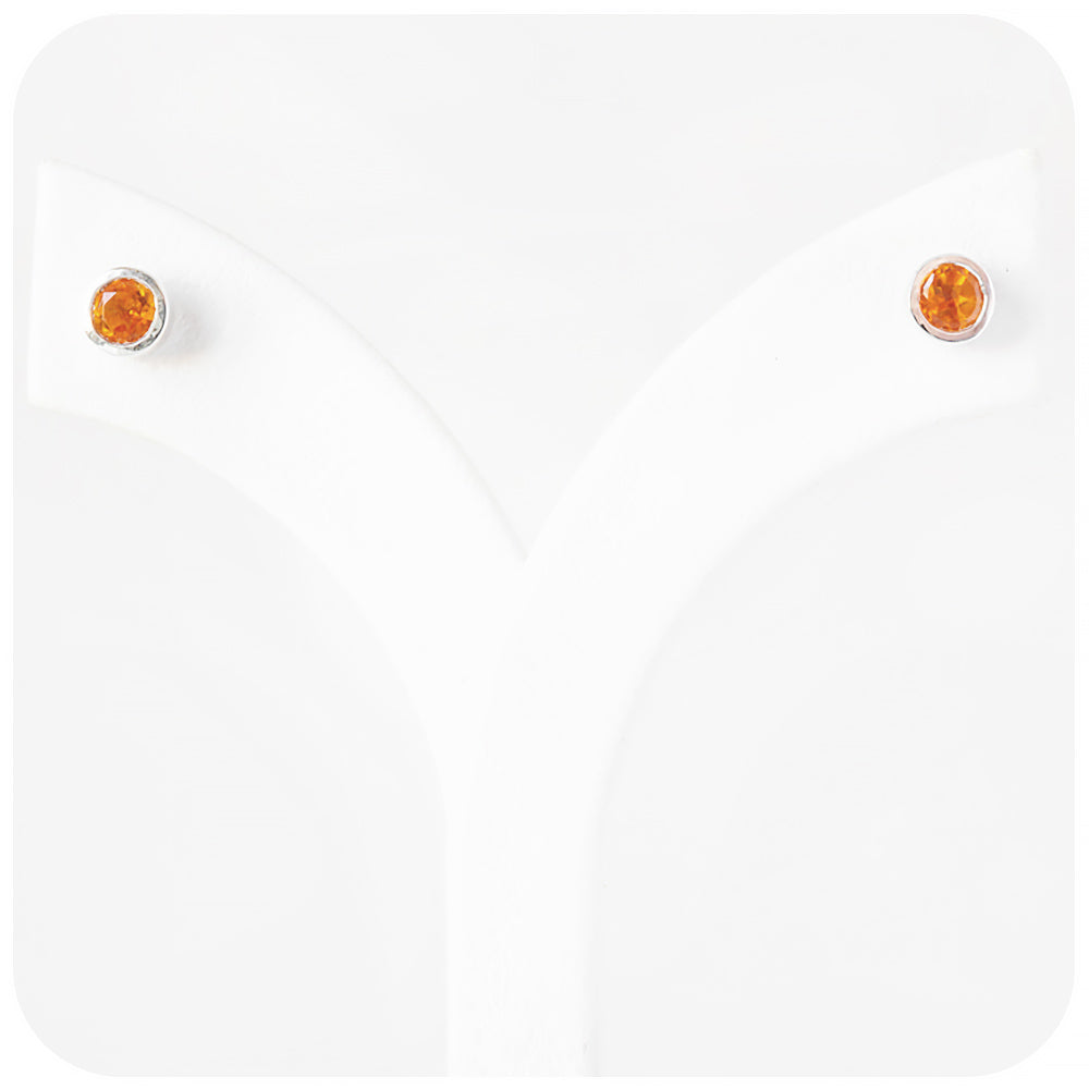 round cut yellow citrine stud earrings in a sterling silver bezel tube setting