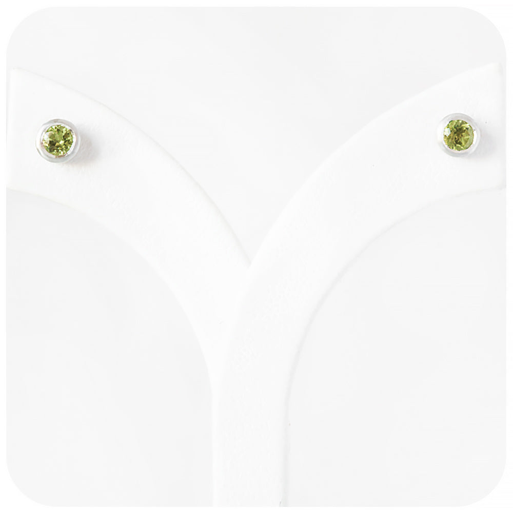 round cut green peridot stud earrings in a sterling silver bezel tube setting