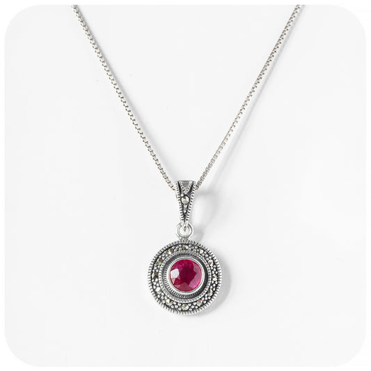 round cut ruby pendant in a marcasite halo with a vintage inspired look