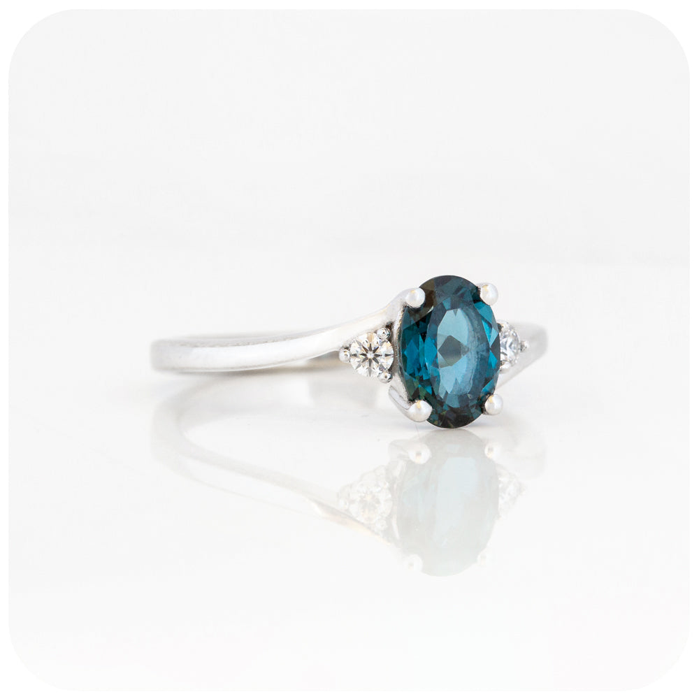 Oval cut London Blue Topaz and Moissanite Trilogy Ring with a Twist