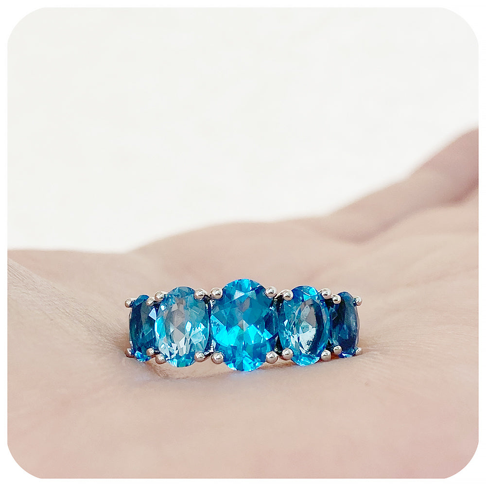 oval cut swiss blue topaz graduated half eternity anniversary or birthday ring