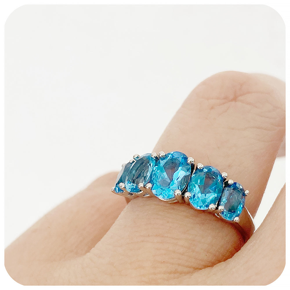 oval cut swiss blue topaz graduated half eternity anniversary or birthday ring