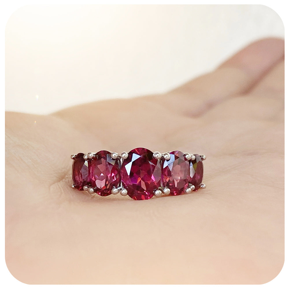 oval cut pink-ish red rhodolite garnet half eternity anniversary ring
