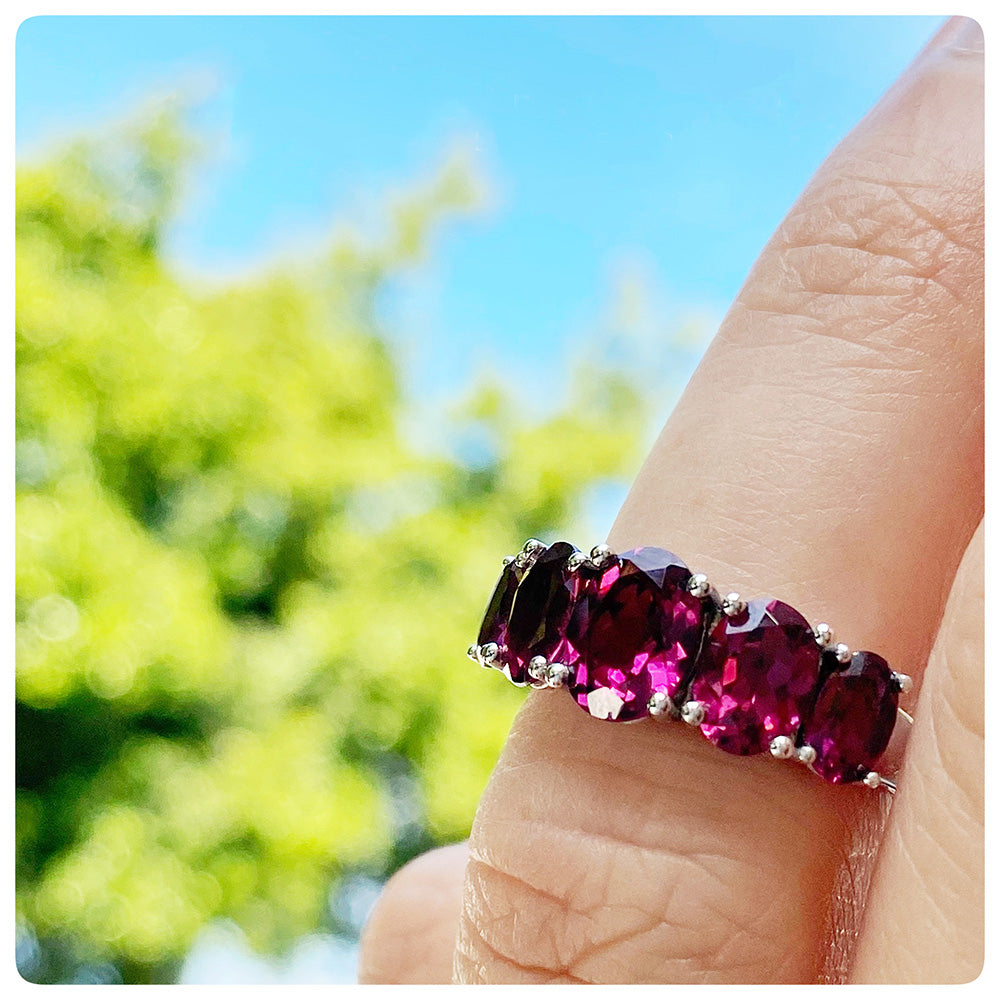 oval cut pink-ish red rhodolite garnet half eternity anniversary ring