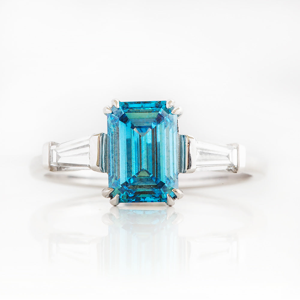 Carmen, a Blue Emerald cut Trilogy Ring