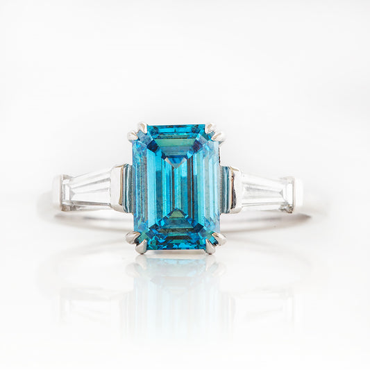 Carmen, a Blue Emerald cut Trilogy Ring