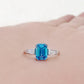 Carmen, a Blue Emerald cut Trilogy Ring