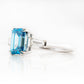 Carmen, a Blue Emerald cut Trilogy Ring
