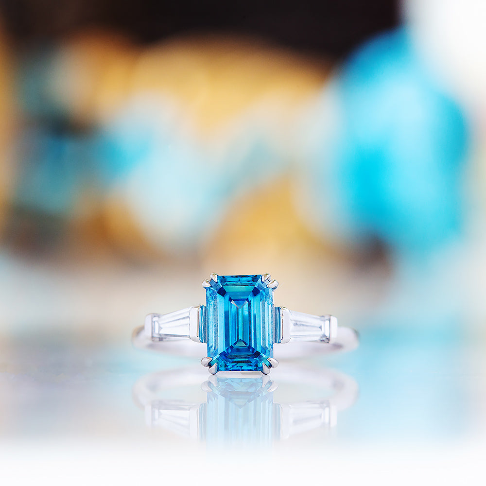 Carmen, a Blue Emerald cut Trilogy Ring