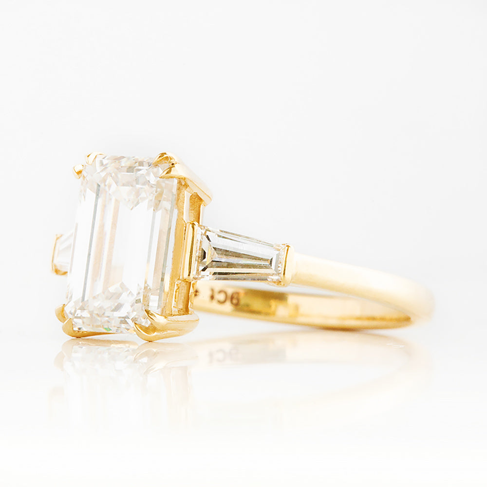 Carmen, an Emerald cut Trilogy Ring