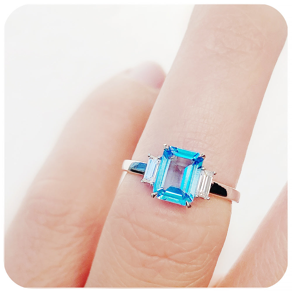 Emerald cut Swiss Blue Topaz and Baguette cut Moissanite Trilogy Engagement Ring - Victoria's Jewellery