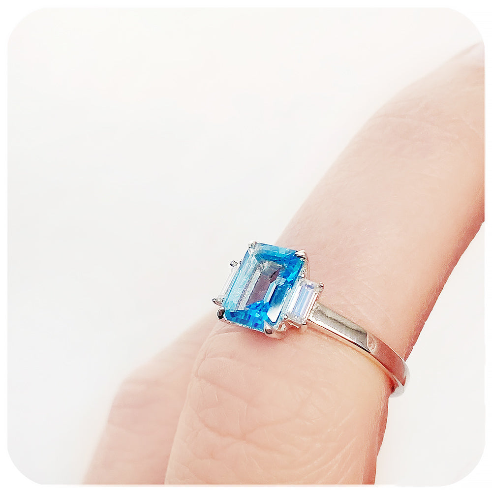 Emerald cut Swiss Blue Topaz and Baguette cut Moissanite Trilogy Engagement Ring - Victoria's Jewellery