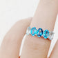 Oval cut Blue Topaz Rainbow half eternity ring - Victoria's Jewellery