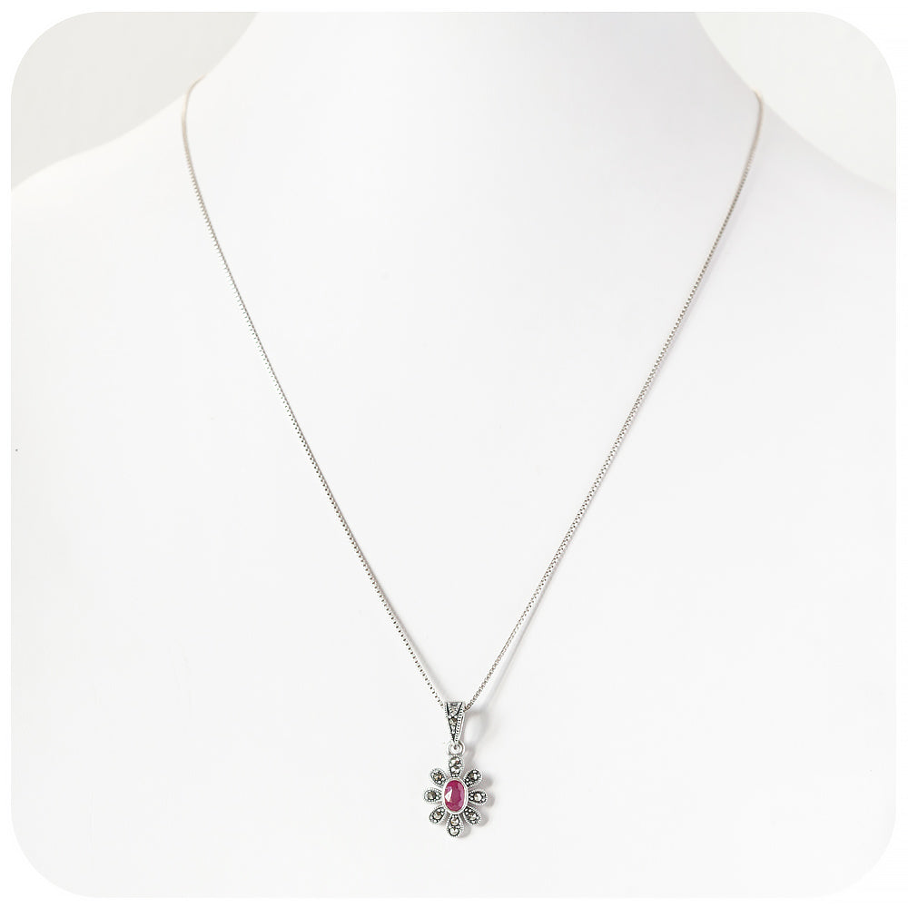 oval cut ruby pendant in a vintage inspired flower setting
