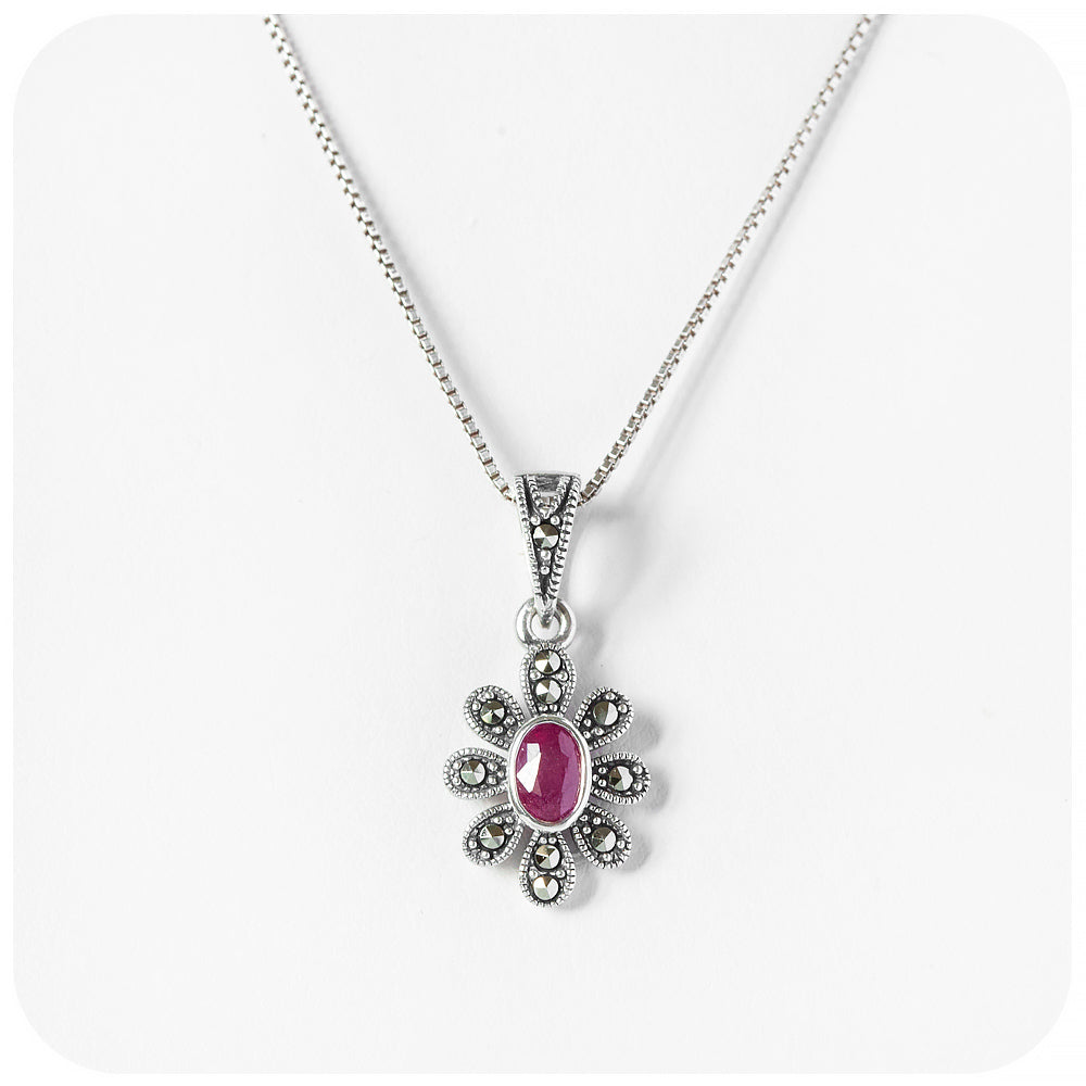 oval cut ruby pendant in a vintage inspired flower setting