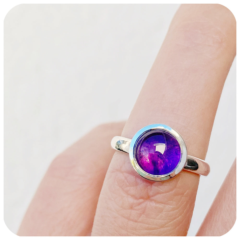 round cabochon amethyst solitaire ring in a bezel setting