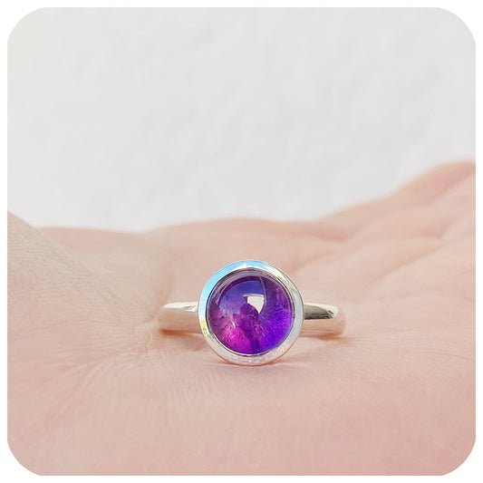 round cabochon amethyst solitaire ring in a bezel setting