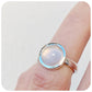 round cabochon rose quartz solitaire ring in a bezel setting