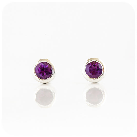 round cut purple amethyst stud earrings in a sterling silver bezel tube setting
