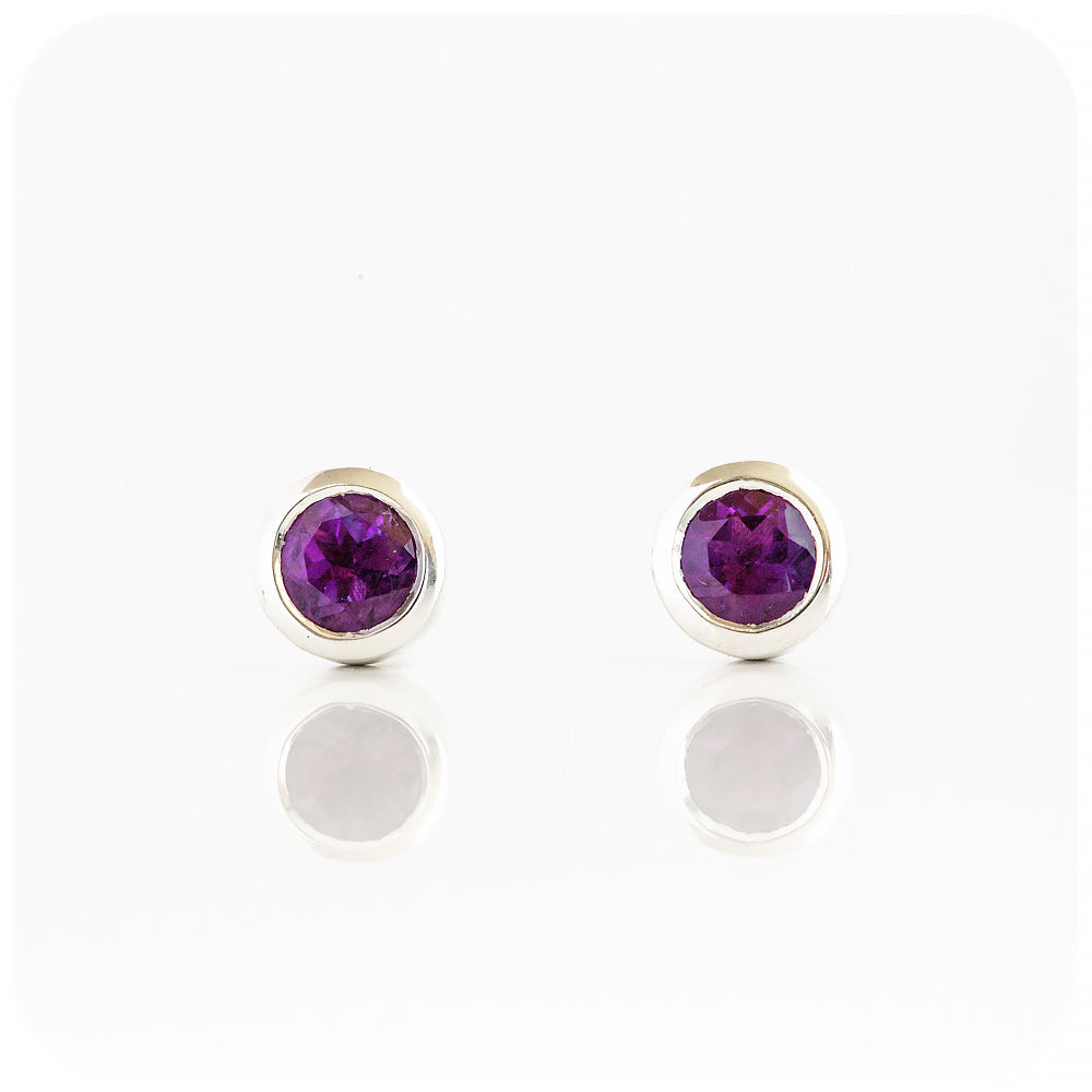 round cut purple amethyst stud earrings in a sterling silver bezel tube setting