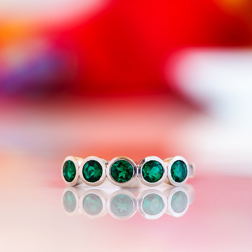 Violet, a Lab Emerald Bezel Set Half Eternity Ring