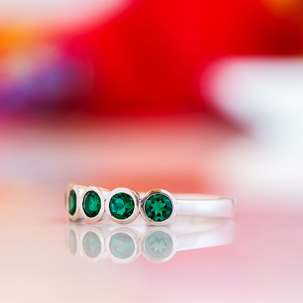 Violet, a Lab Emerald Bezel Set Half Eternity Ring