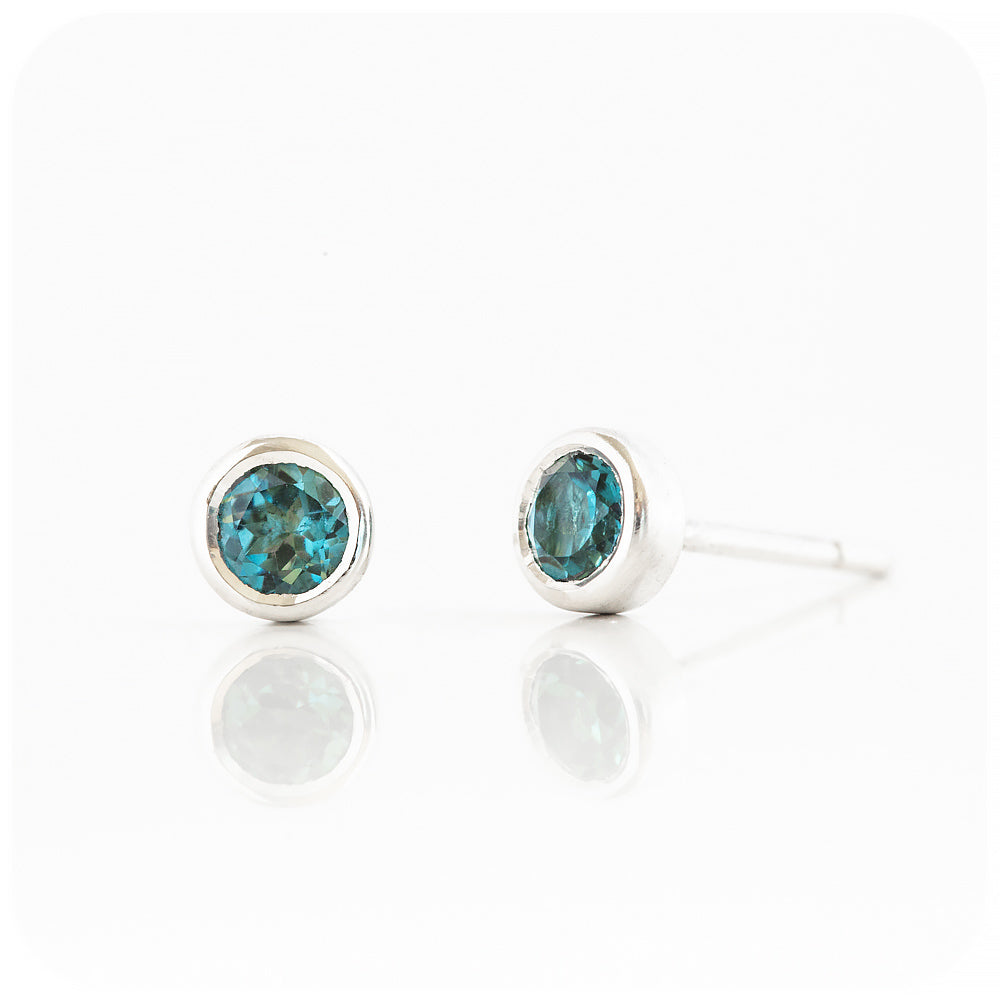 round cut blue london topaz stud earrings in a sterling silver bezel tube setting