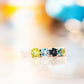 Annie, a Peridot and Topaz Half Eternity Ring