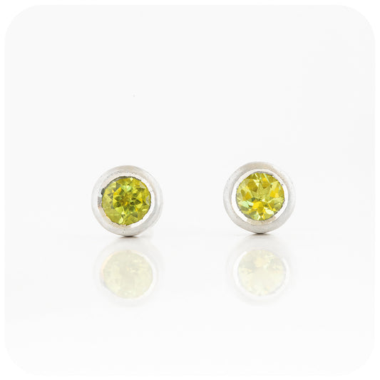 round cut green peridot stud earrings in a sterling silver bezel tube setting