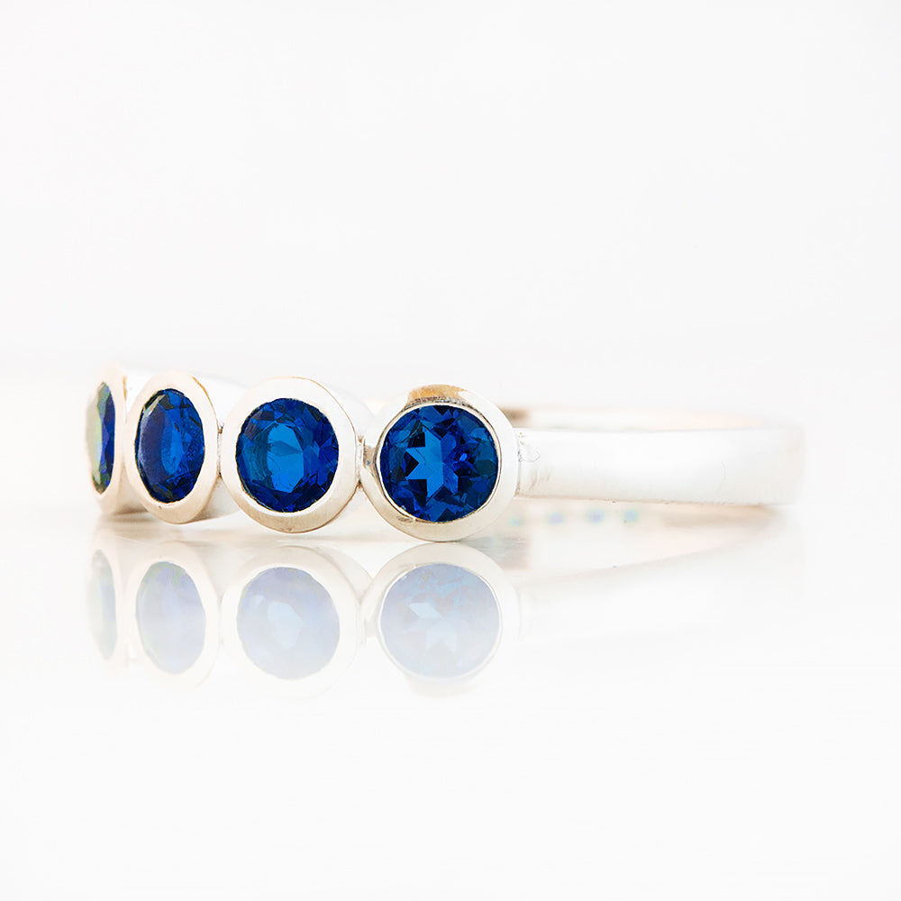 Violet, a Lab Sapphire Bezel Set Half Eternity Ring