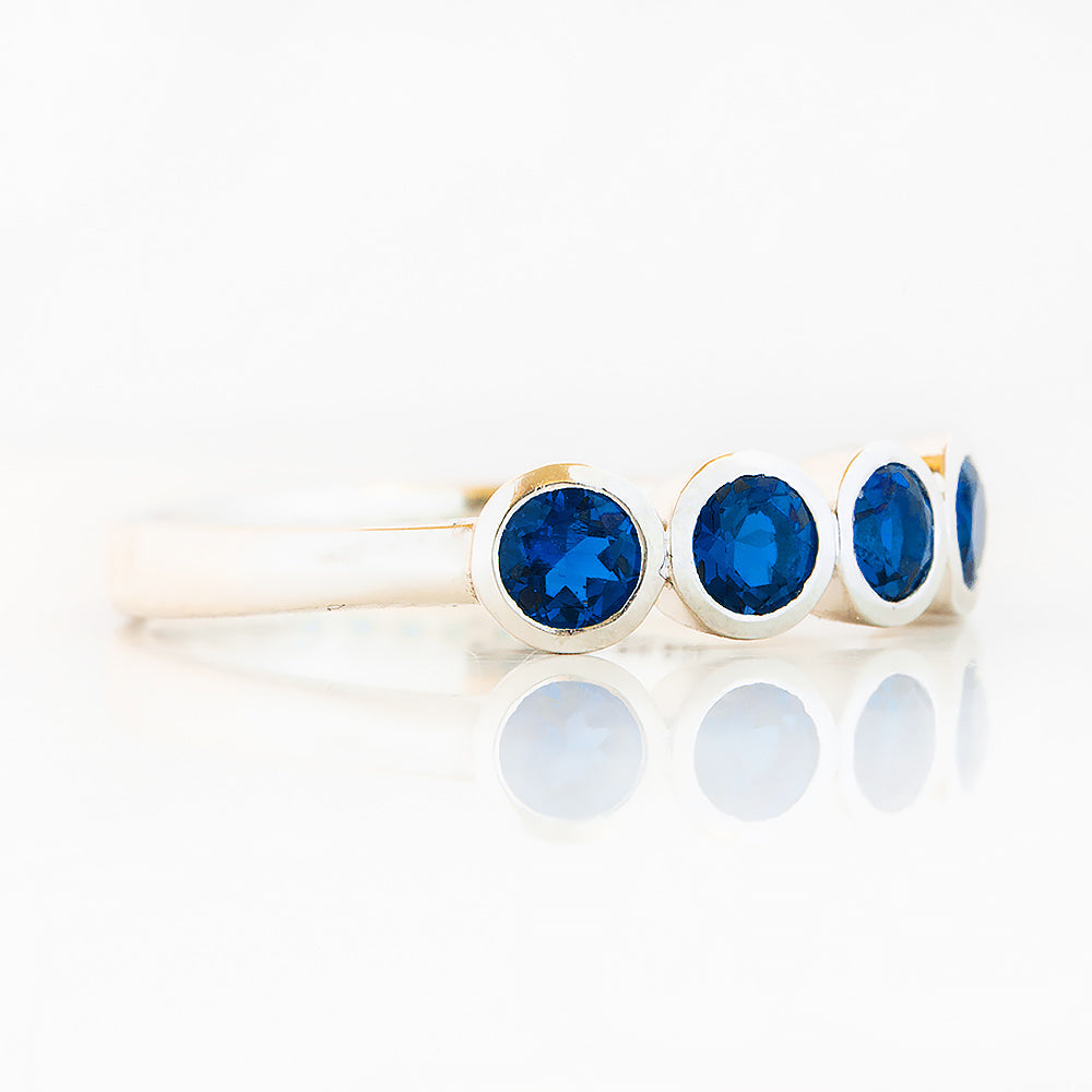 Violet, a Lab Sapphire Bezel Set Half Eternity Ring