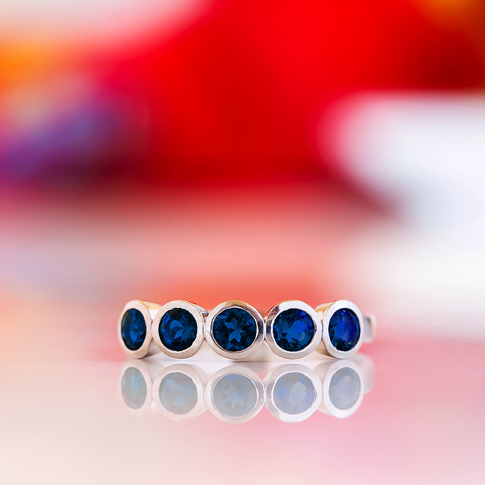 Violet, a Lab Sapphire Bezel Set Half Eternity Ring