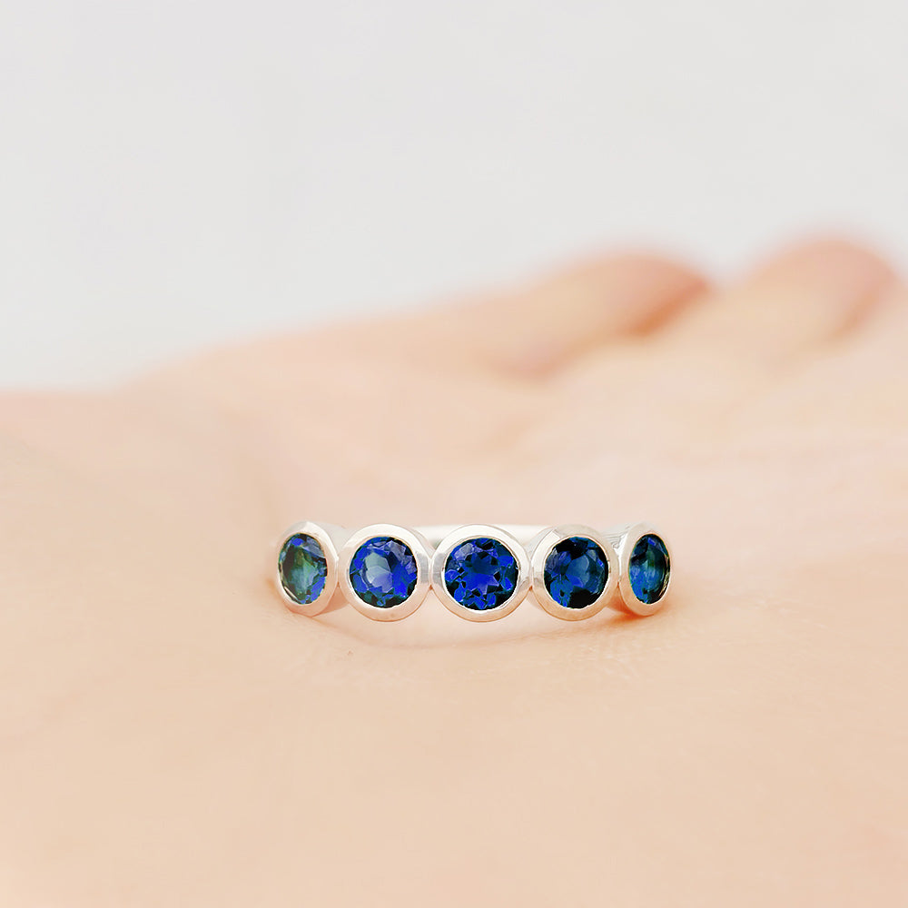Violet, a Lab Sapphire Bezel Set Half Eternity Ring
