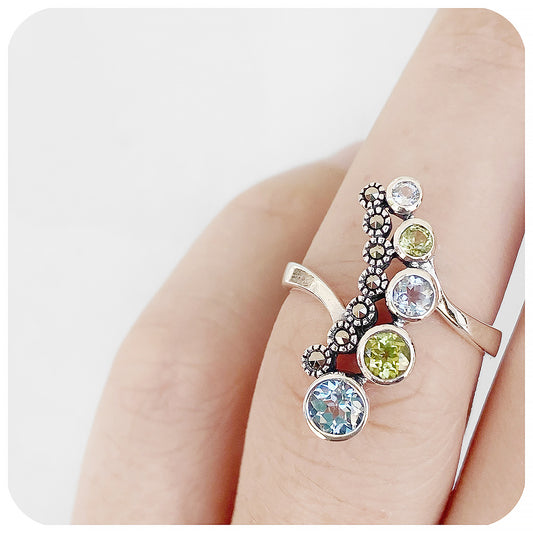 vintage inspired round cut blue topaz and peridot cocktail ring