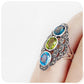 vintage inspired oval cut blue topaz and peridot trilogy style ring