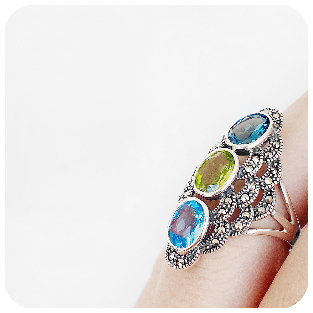 vintage inspired oval cut blue topaz and peridot trilogy style ring