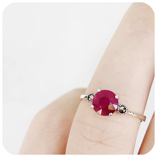 round cut ruby trilogy style ring in silver