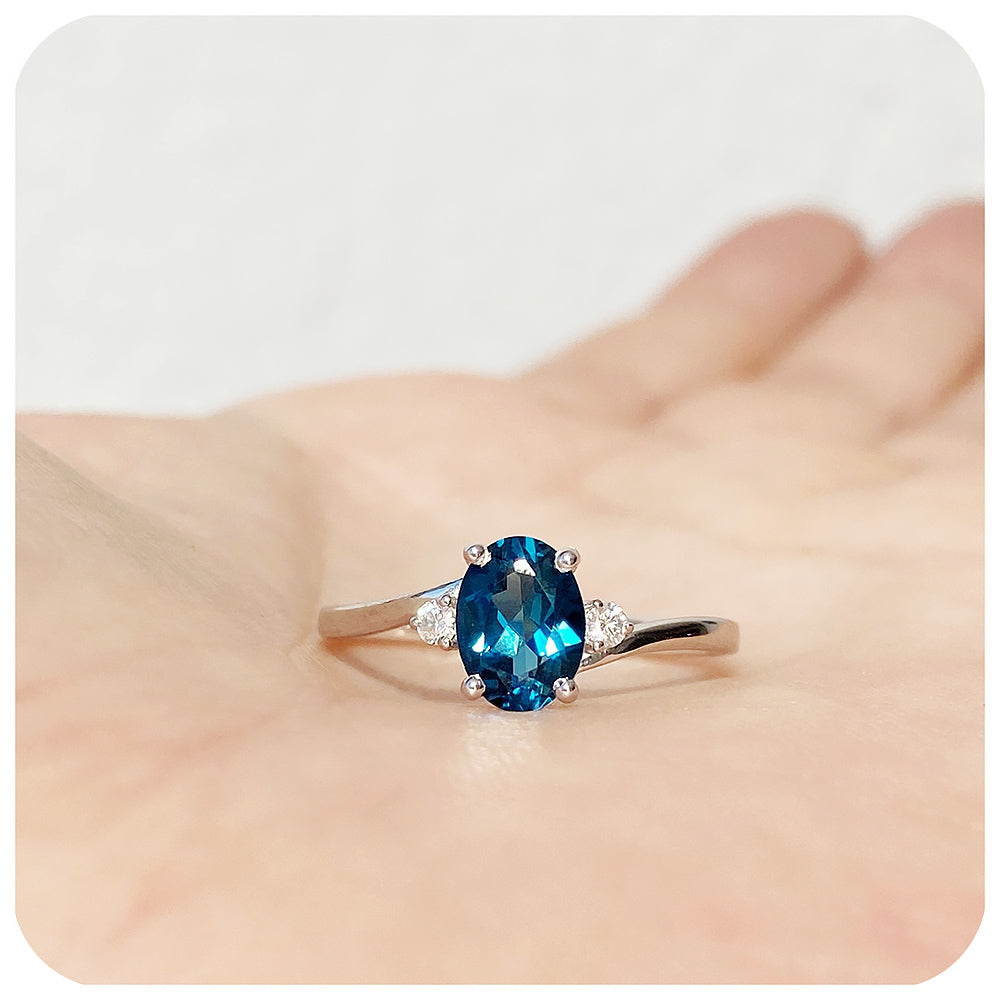 Oval cut London Blue Topaz  and Moissanite Trilogy Ring with a Twist - 8x6mm