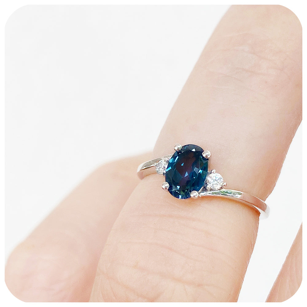 Oval cut London Blue Topaz and Moissanite Trilogy Ring with a Twist