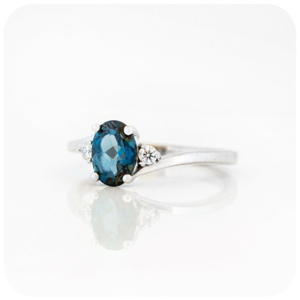 Oval cut London Blue Topaz and Moissanite Trilogy Ring with a Twist