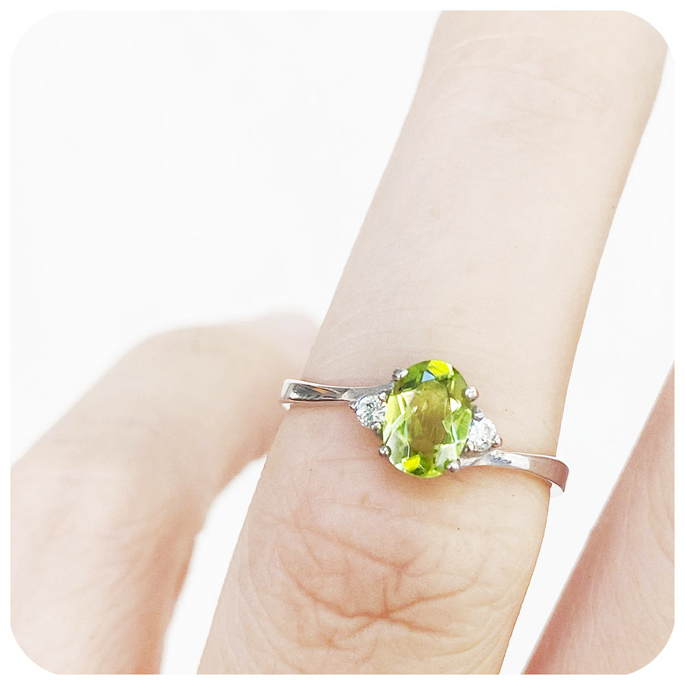 Oval cut Peridot and Moissanite Trilogy Ring with a Twist