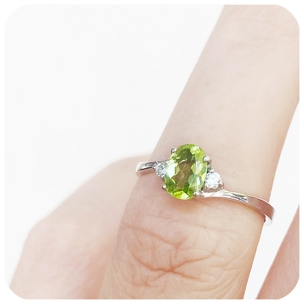 Oval cut Peridot and Moissanite Trilogy Ring with a Twist
