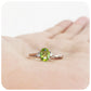 Oval cut Peridot and Moissanite Trilogy Ring with a Twist